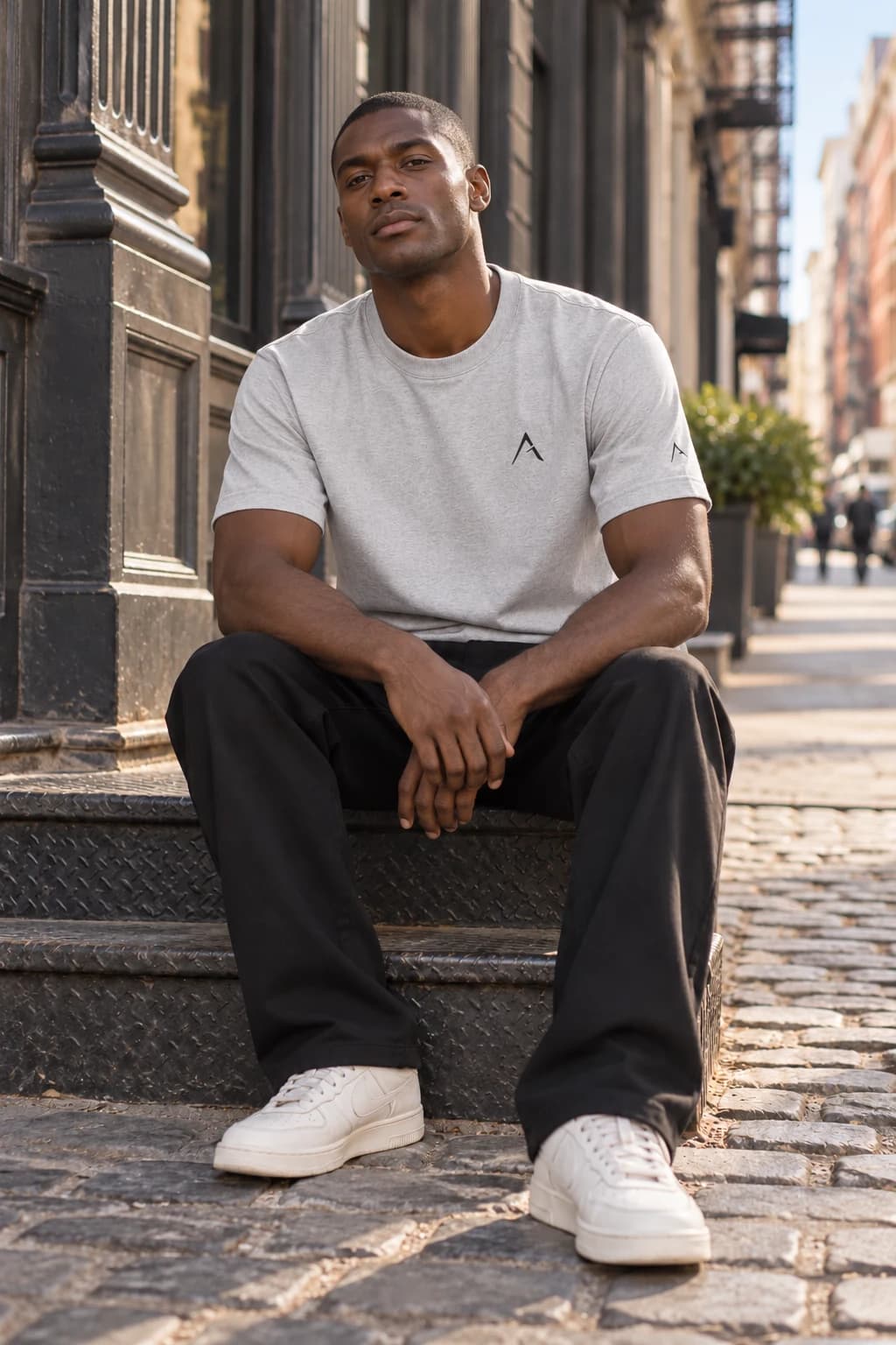 Generated ALTIOR editorial: adult man wearing carbon ash core tee in a SoHo-inspired setting.