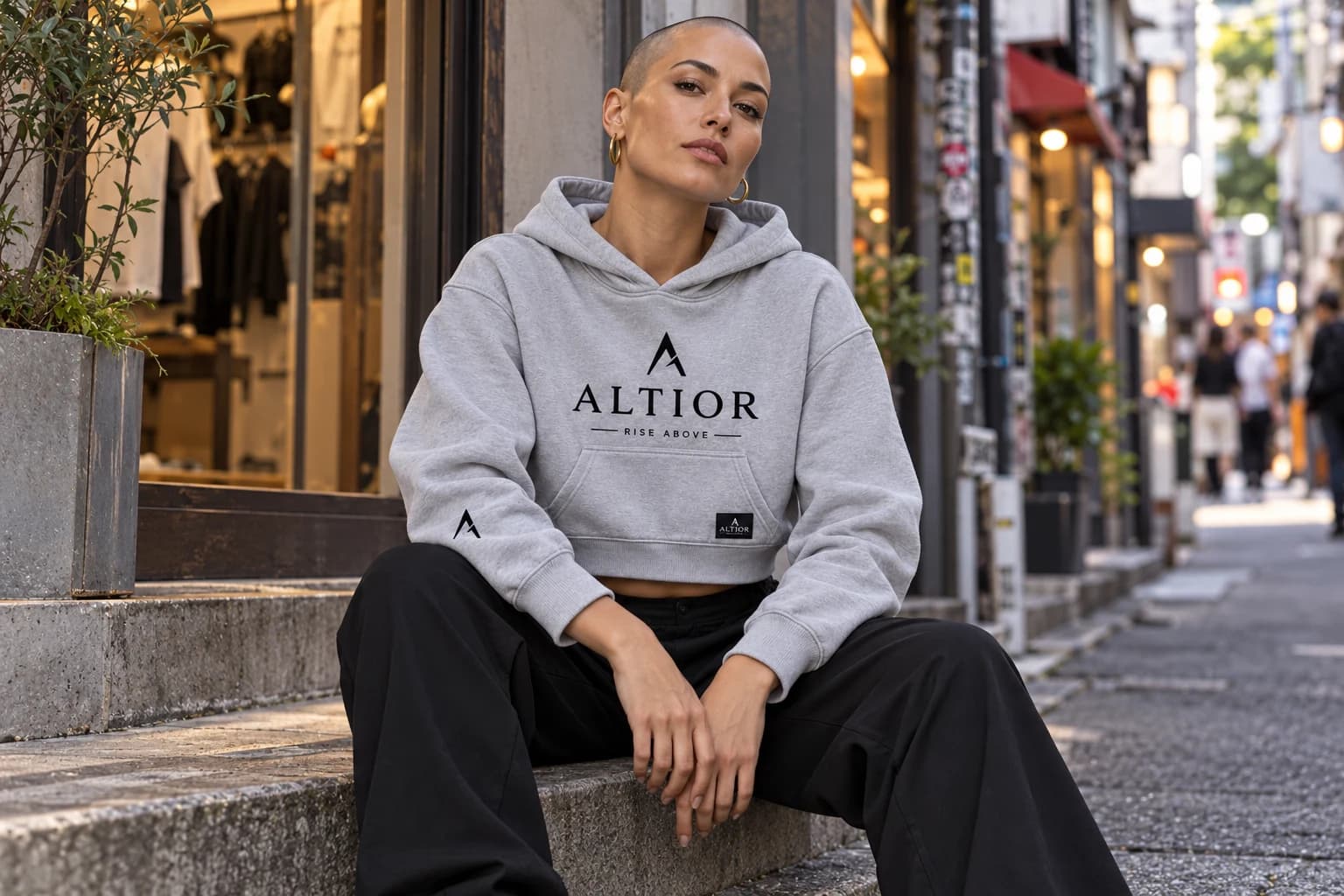 Generated ALTIOR editorial: adult woman wearing carbon ash elevate crop hoodie in a Harajuku backstreet-inspired setting.