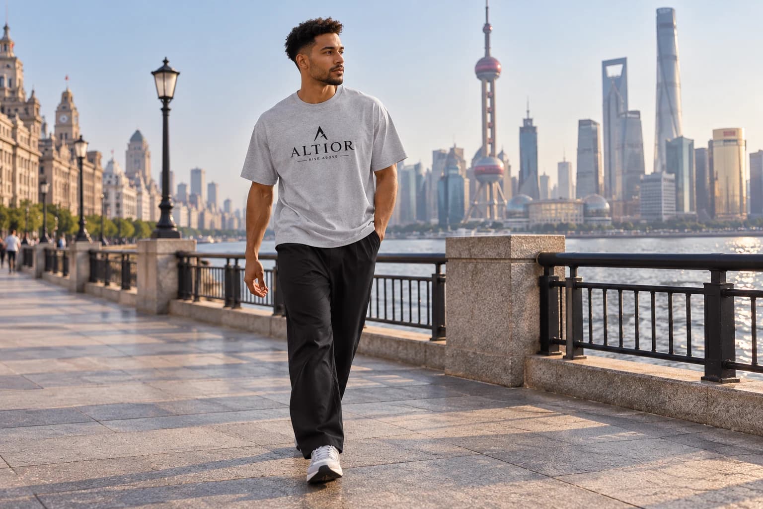 Generated ALTIOR editorial: adult man wearing carbon ash ascend tee in a Shanghai waterfront-inspired setting.