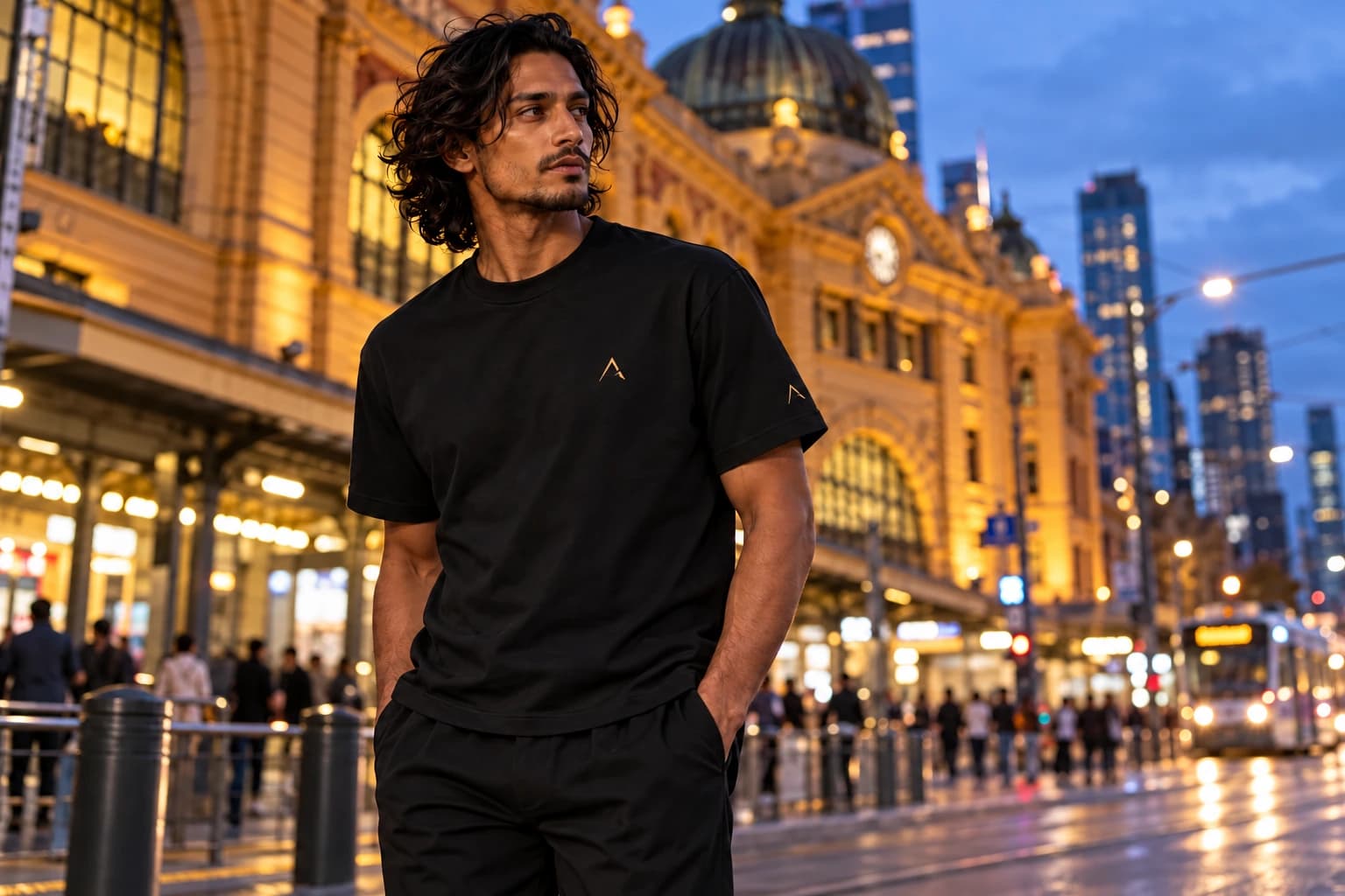 ALTIOR black Core tee with fine gold detailing outside Flinders Street Station at dusk