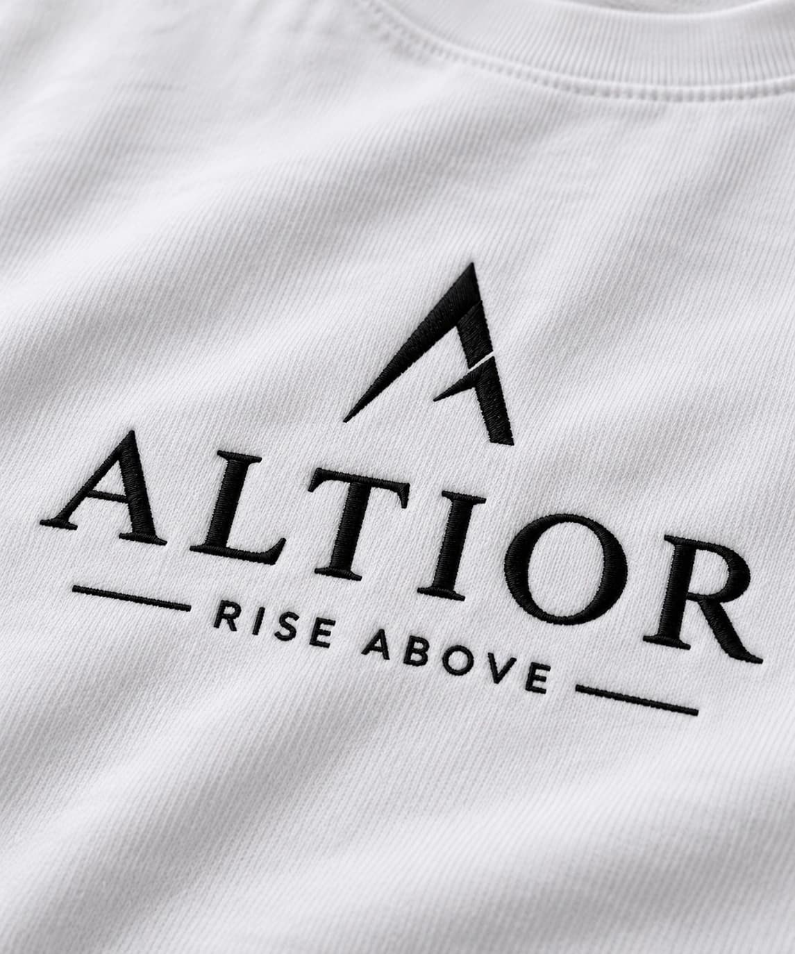 Cropped tee — White with black detailing, AI-generated embroidered branding close-up