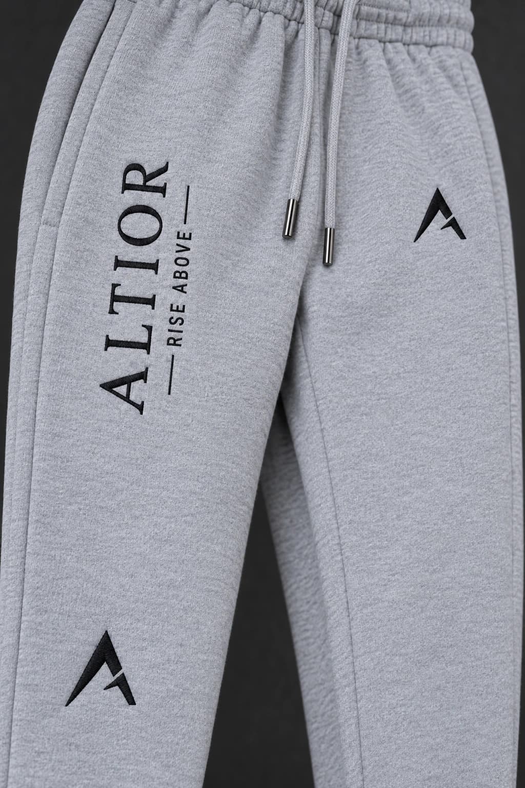 Track pants — Grey with black detailing, AI-generated embroidered branding close-up